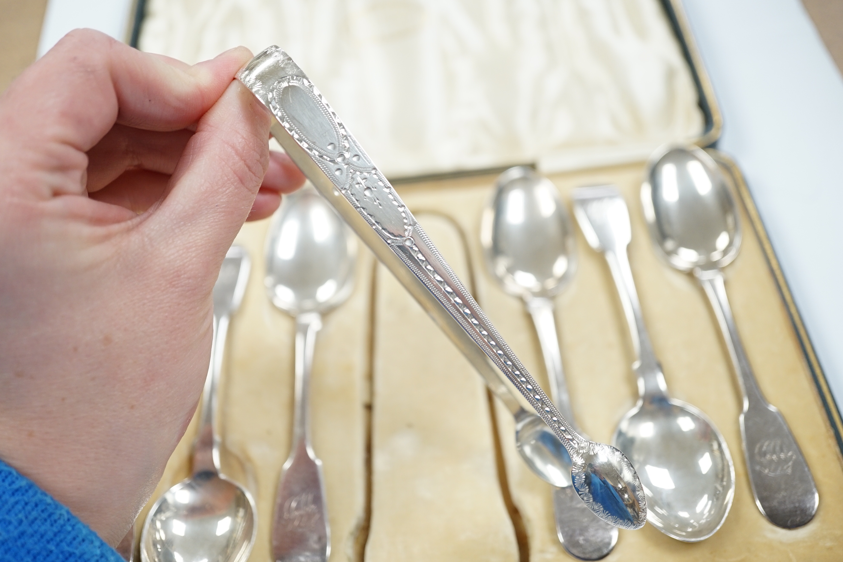 A set of six Victorian provincial silver fiddle pattern teaspoons, Reid & Sons, Newcastle, 1873 and a pair of associated silver sugar tongs, in associated case.